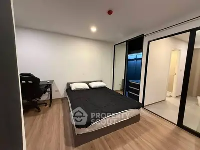 Modern bedroom with sleek design and study area, featuring a comfortable bed and ample storage.