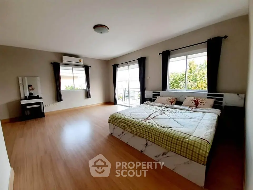 Spacious bedroom with large windows and modern decor