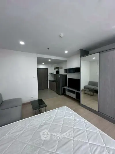 Modern studio apartment with sleek design, featuring a cozy living area and compact kitchen.