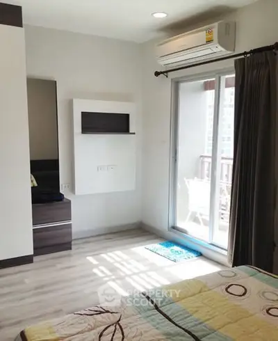 Bright bedroom with balcony access and modern air conditioning unit
