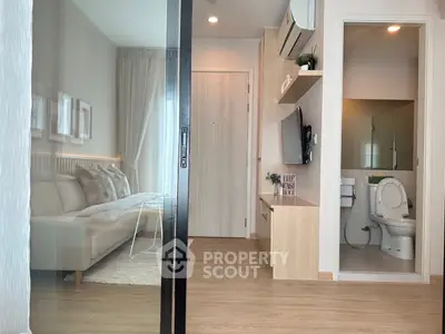 Modern apartment interior with cozy living room and compact bathroom, featuring sleek design and neutral tones.