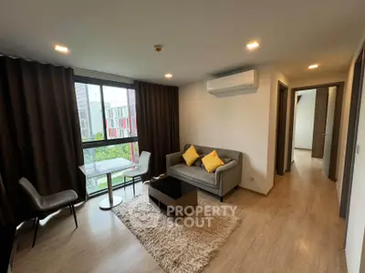 Modern living room with cozy sofa, stylish decor, and large window view.