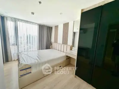 Modern bedroom with large windows and sleek storage solutions in urban apartment.