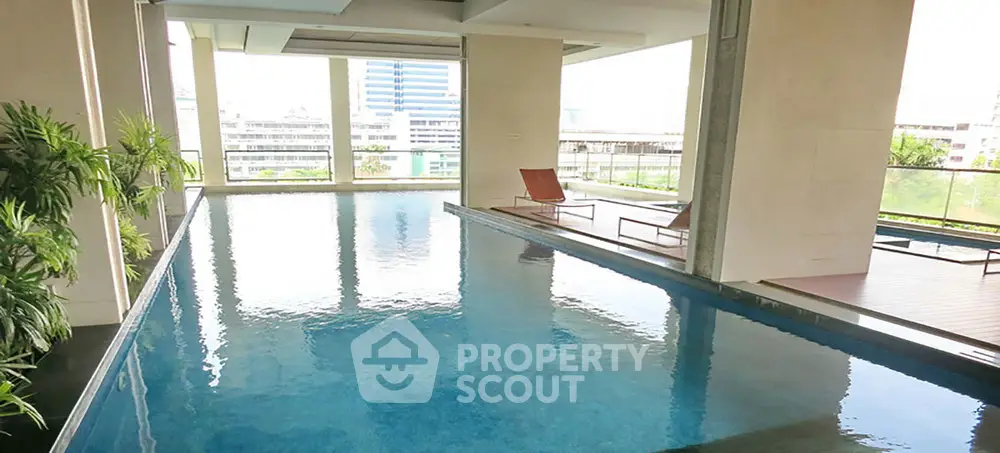 Luxurious indoor pool with city view and modern design, perfect for relaxation and leisure.