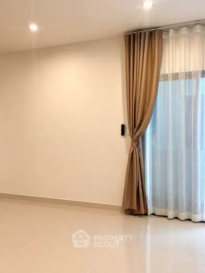 Spacious empty room with elegant curtains and polished tile flooring, perfect for customization.