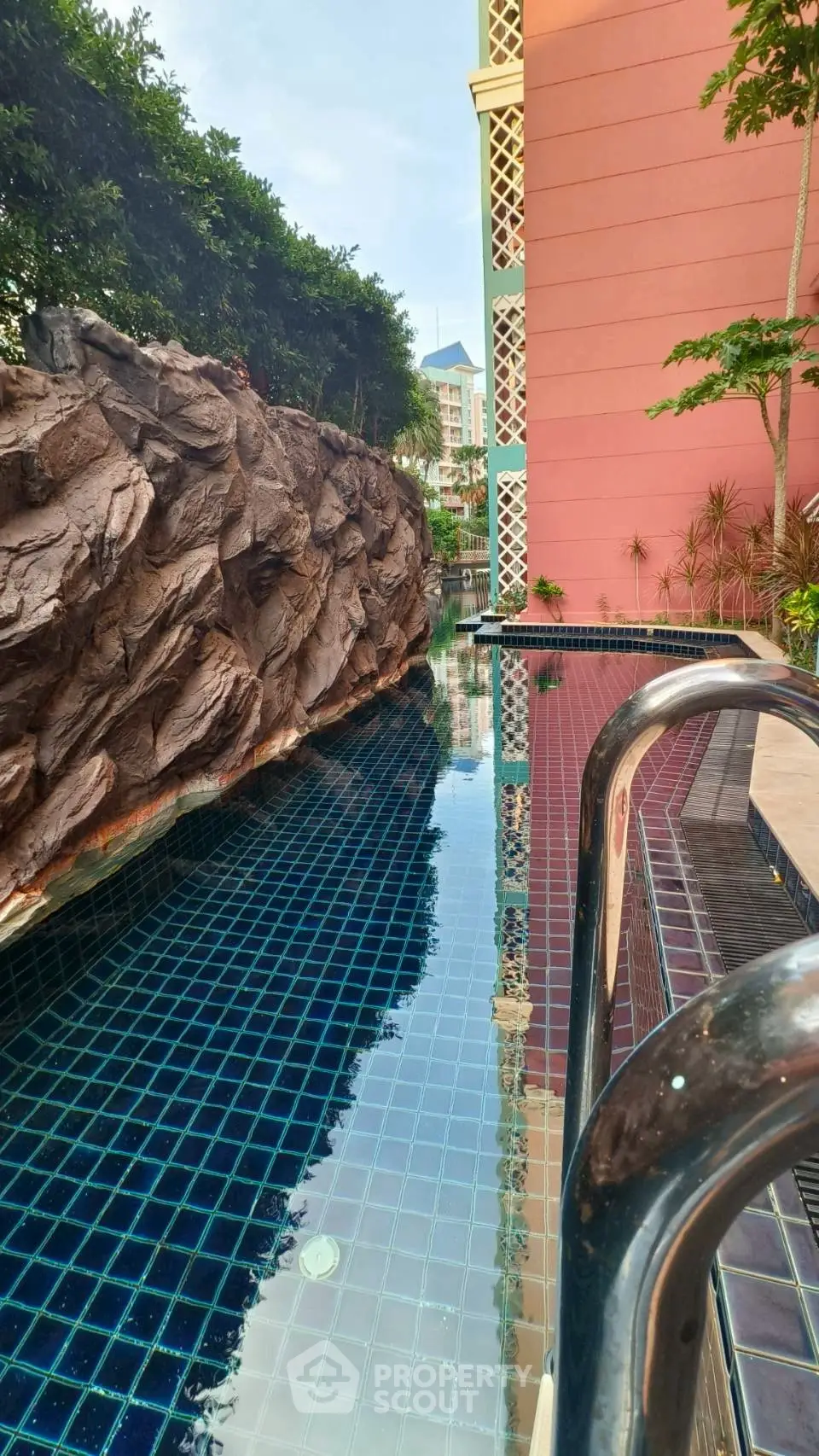 Luxurious poolside view with modern architecture and lush greenery, perfect for relaxation and leisure.