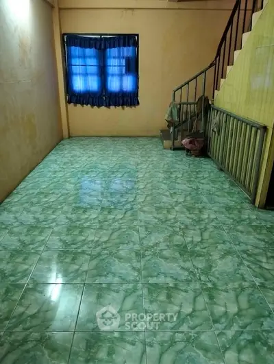 Spacious interior with green marble flooring and staircase, ideal for creative renovation.