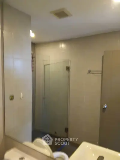 Modern bathroom with glass shower enclosure and sleek fixtures.