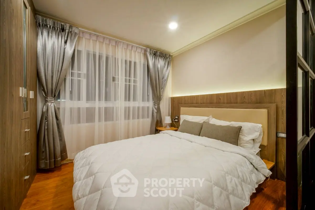 Luxurious bedroom with elegant decor and ambient lighting, featuring plush bedding and stylish curtains.