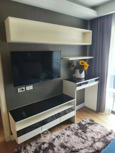 Modern living room with sleek TV unit and sunflowers on a console table, featuring elegant decor.