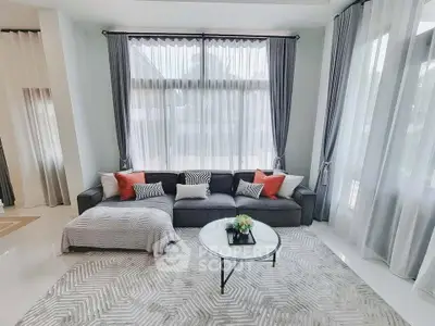 Elegant living room with large windows, stylish sofa, and modern decor