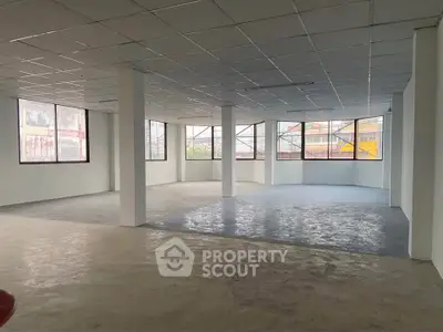 Spacious open-plan commercial space with large windows and natural light