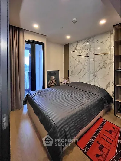 Luxurious bedroom with marble accent wall and balcony access in modern apartment.