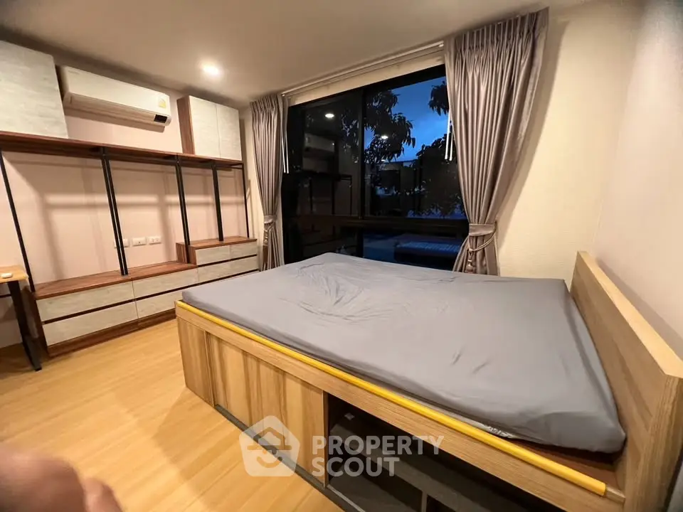 Spacious bedroom with modern design and large window offering serene views.