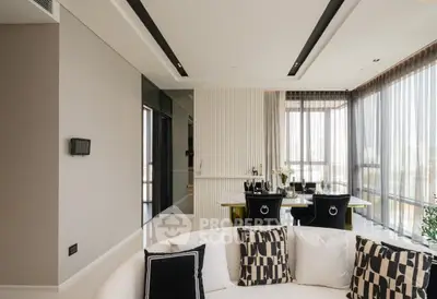 Luxurious modern living room with elegant decor and large windows offering abundant natural light.
