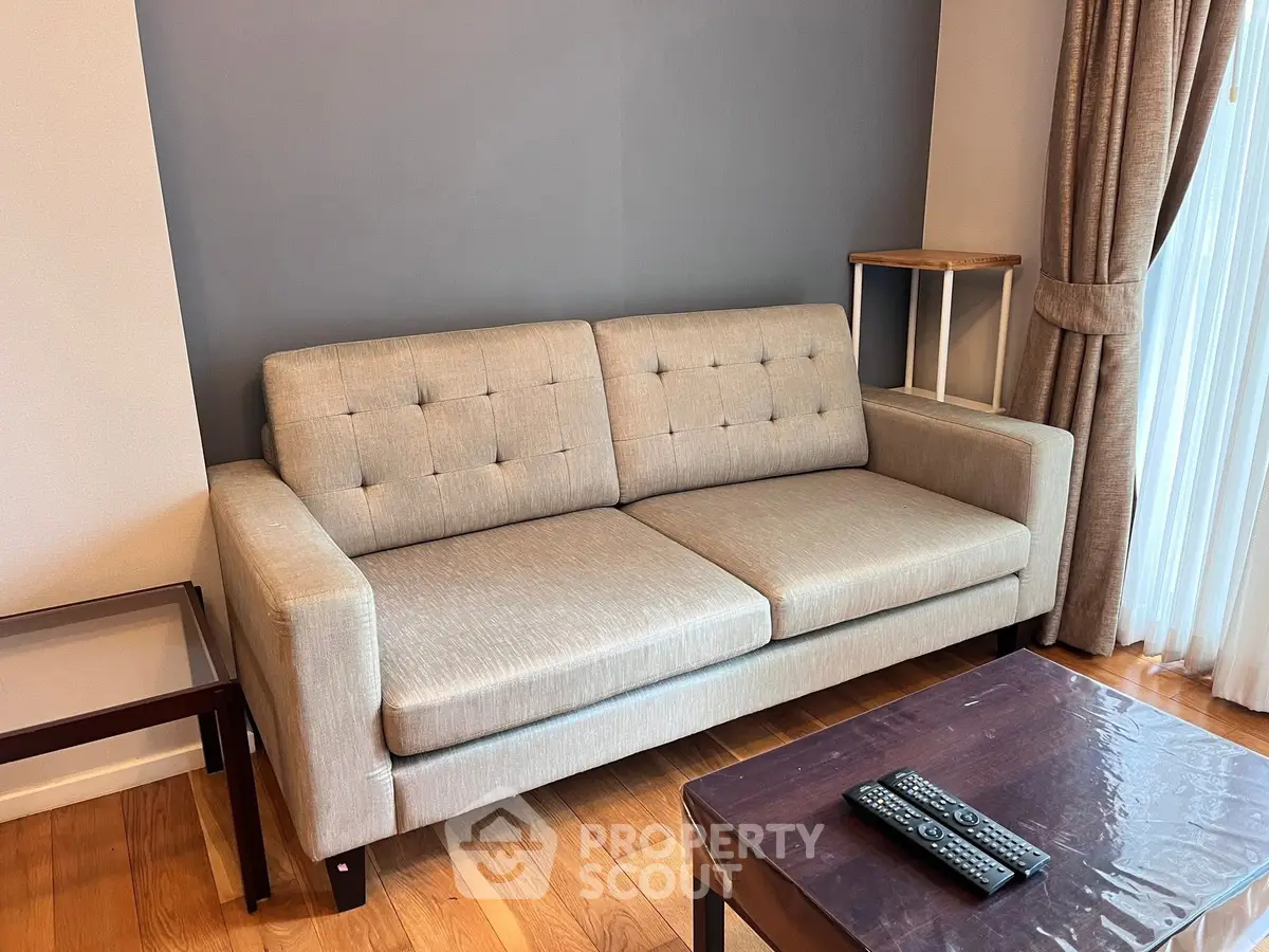 Cozy living room with modern beige sofa and wooden coffee table, perfect for relaxation.