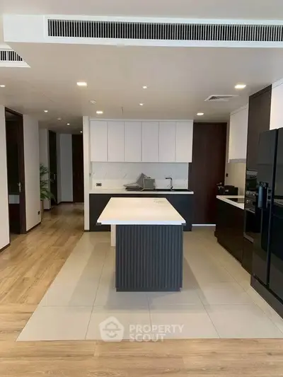 Modern kitchen with sleek island and high-end appliances in luxury apartment.