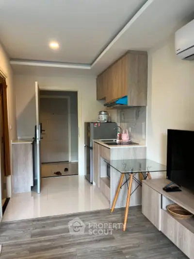 Modern compact kitchen with open layout and stylish wooden cabinetry in a cozy apartment.