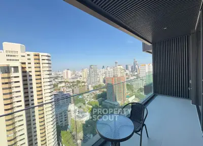 Stunning city view from a modern balcony with glass railing and outdoor seating.