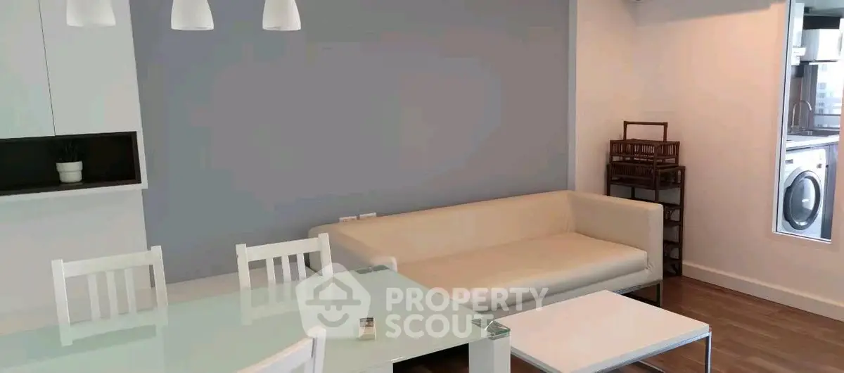 Modern living room with sleek white furniture and dining area