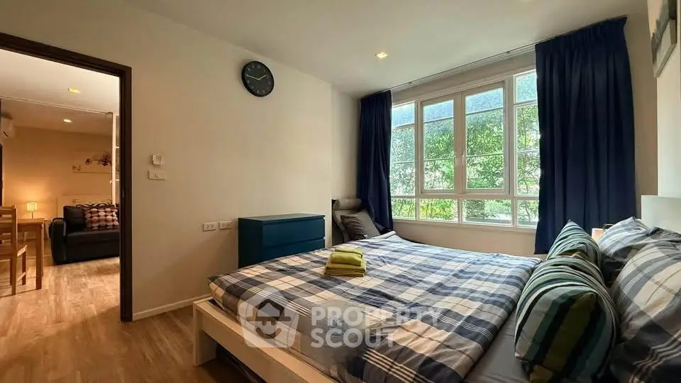 Cozy bedroom with large window and stylish decor in modern apartment