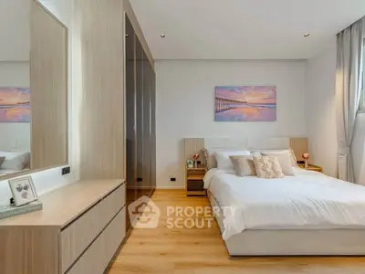 Elegant bedroom with modern decor and large wardrobe, featuring a cozy bed and stylish artwork.