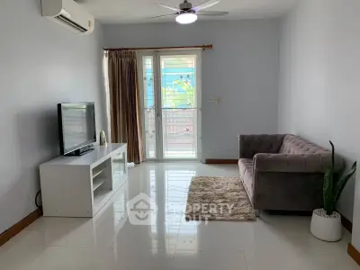 Spacious living room with modern decor, featuring a plush sofa, sleek TV stand, and large window for natural light.