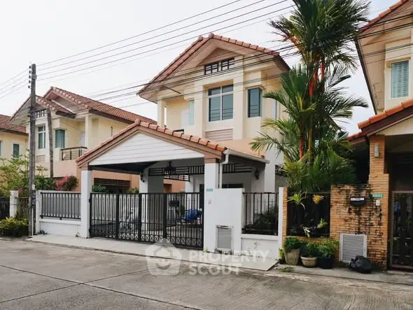 Charming suburban house with tiled roof and gated driveway in a peaceful neighborhood.