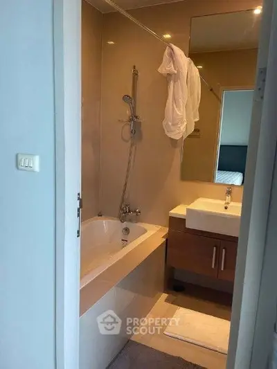 Modern bathroom with bathtub and sleek vanity in a stylish apartment.