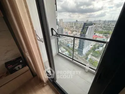 Stunning city view from modern high-rise balcony with glass railing and wooden flooring.