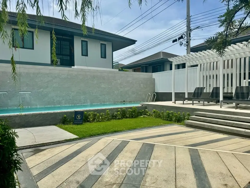 Luxurious modern home with private pool and stylish outdoor lounge area, perfect for relaxation.
