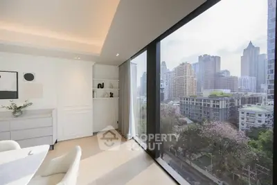 Luxurious modern living room with panoramic city view through large windows, featuring elegant decor and natural light.