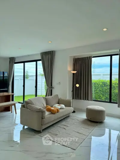 Bright and modern living room with large windows and cozy furniture