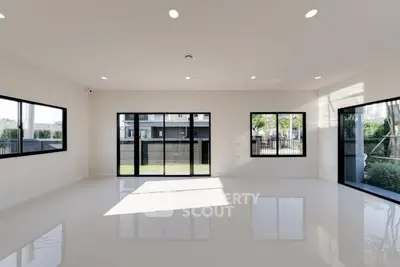 Spacious modern living room with large windows and glossy floors
