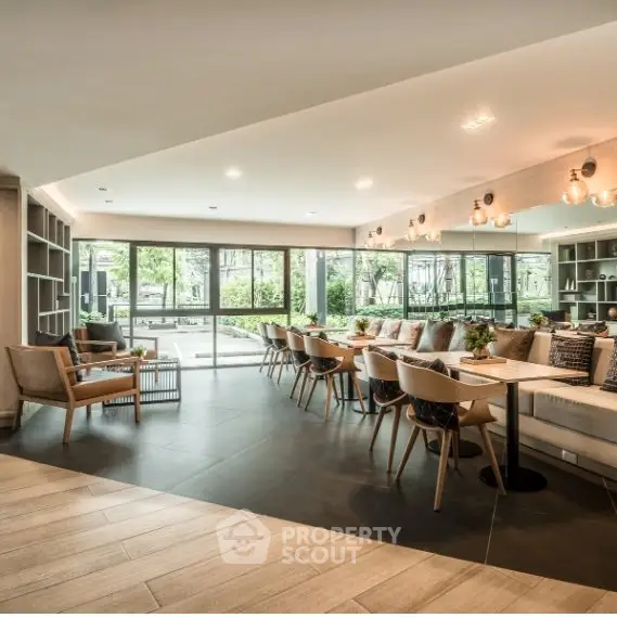 Spacious modern living room with elegant furniture and large windows offering garden views.