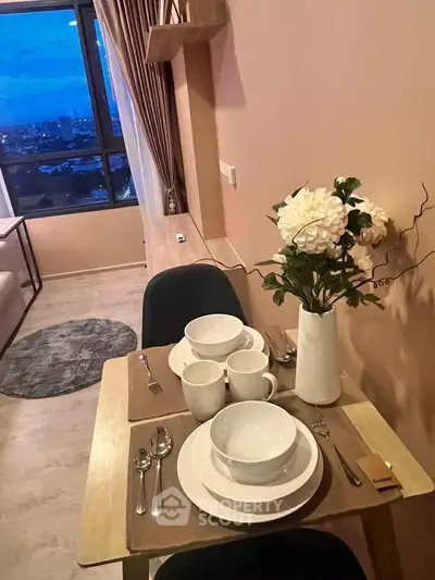 Cozy dining area with city view, elegant table setting, and modern decor in a stylish apartment.