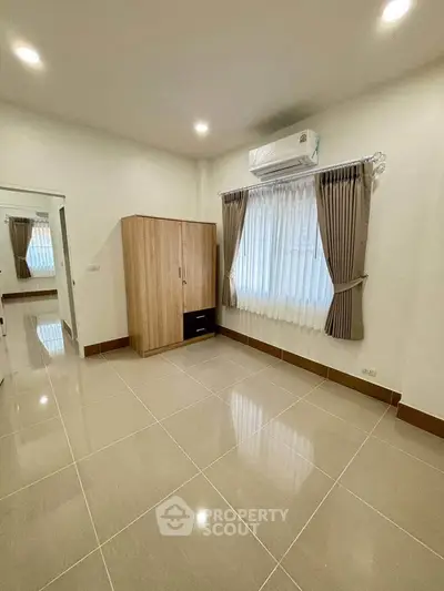 Spacious bedroom with modern wardrobe and air conditioning in a bright, minimalist design.
