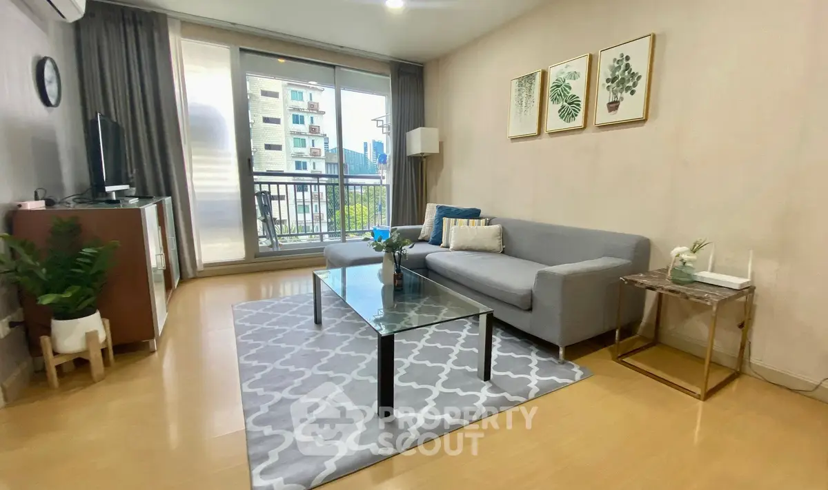 Stylish living room with modern decor and balcony view in urban apartment.