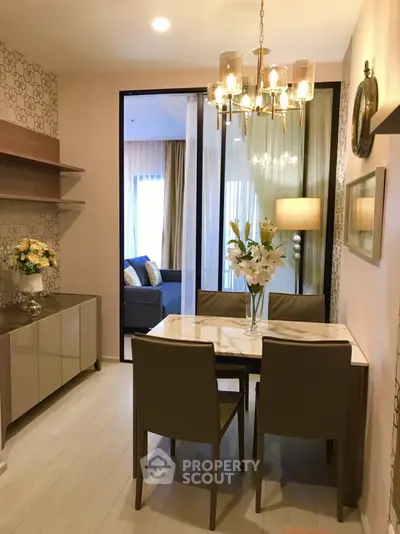 Elegant dining area with chandelier and modern decor in open-plan apartment