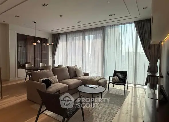 Luxurious living room with modern furniture and floor-to-ceiling windows offering stunning city views.