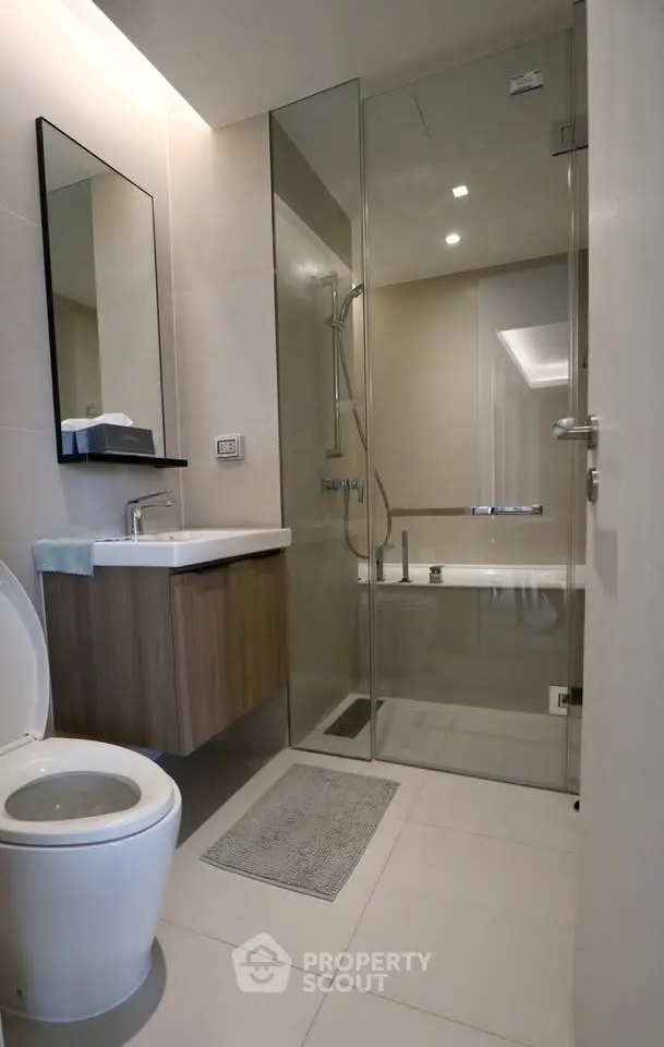 Modern bathroom with glass shower and sleek fixtures in a contemporary apartment.