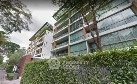 Modern apartment building with lush greenery and large windows