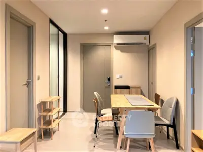 Modern dining area with sleek furniture and air conditioning in a cozy apartment.