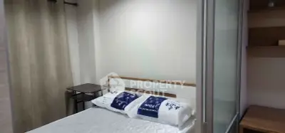Cozy bedroom with modern design and ample natural light, featuring a comfortable bed and stylish decor.