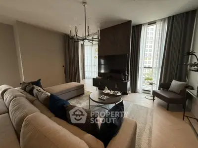 Luxurious modern living room with elegant decor and large windows offering natural light.