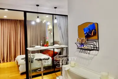 Modern studio apartment with cozy dining area and bedroom separated by glass partition.