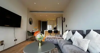 Modern living room with stylish decor and open kitchen layout, featuring cozy seating and elegant dining area.