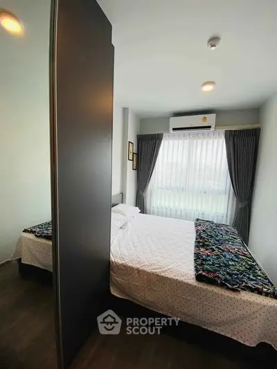 Cozy bedroom with modern decor and large window for natural light