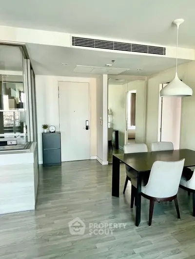 Modern dining area with sleek furniture and stylish lighting in a contemporary apartment.