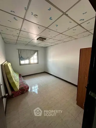 Cozy bedroom with tiled floor and window, ideal for minimalist living.
